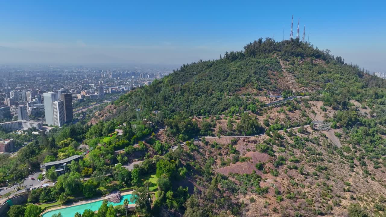 Reveal Drone Shot of San Cristóbal Hill in Santiago, Featuring Cable Cars, Greenery, and Distant City Views