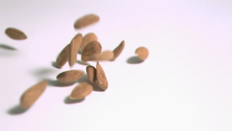 Almonds-falling-in-super-slow-motion-on-a-white-surface