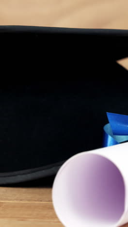 close-up of graduation certificate with mortar board on a table