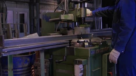 trabajador metalúrgico que opera una máquina industrial de corte de metales