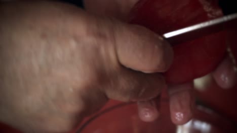 close up of hands cuting a tomato for salad