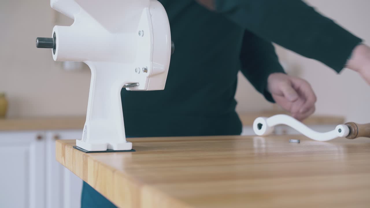 uomo installa un mulino di farina in casa su un tavolo di legno vista ravvicinata