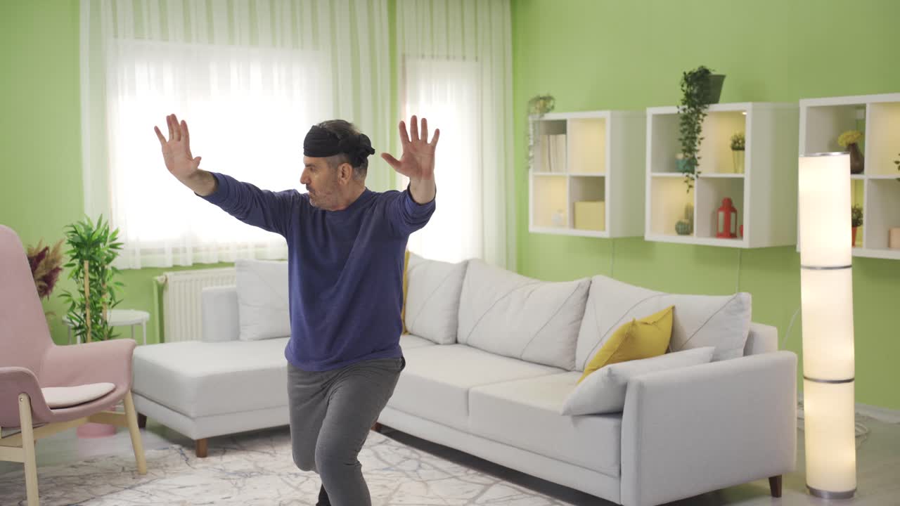 Serious and focused funny old man doing sports at home alone.