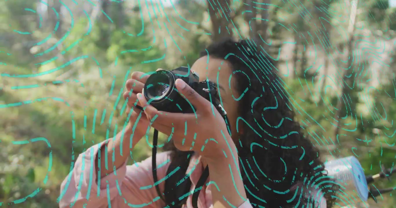 Fotografo guarda in alto verso la chioma degli alberi, afferra la DSLR, mette a fuoco e fotografa la foresta.