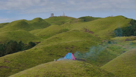 aerial view of shailung in dolakha, nepal, near tibet border, showing camping tent and bonfire on lush green hills und clear and cloudy skies serene nature enjoyment of escaping into wilderness