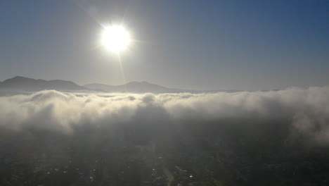 Aerial-view-of-low-fog-over-mountains-in-San-Diego-during-sunrise