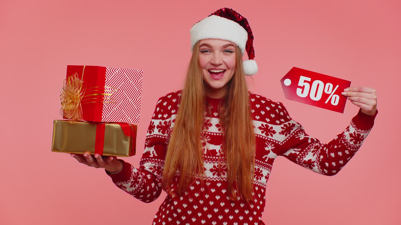 niña con suéter de navidad rojo mostrando caja de regalos y inscripciones de descuento del 50 por ciento nota de texto de banner