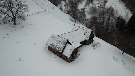 Cabaña-Cubierta-De-Nieve-En-Las-Montañas-Cindrel-Durante-El-Invierno,-Vista-Aérea