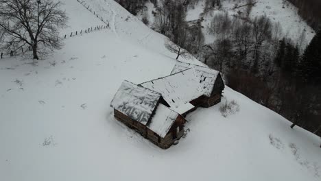 snow-covered cabin in the cindrel mountains during winter, aerial view