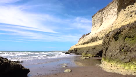 Waves-in-a-cove-under-a-blue-sky-in-Puerto-Madryn,-Chubut,-Argentina,-wide-shot