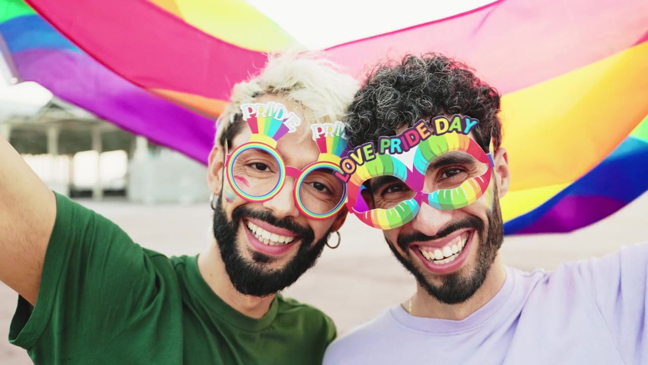 Happy Gay Couple Celebrating Pride with Rainbow Flag