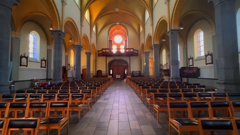 row of black chairs for prayer inside roman catholic church in neerpelt belgium