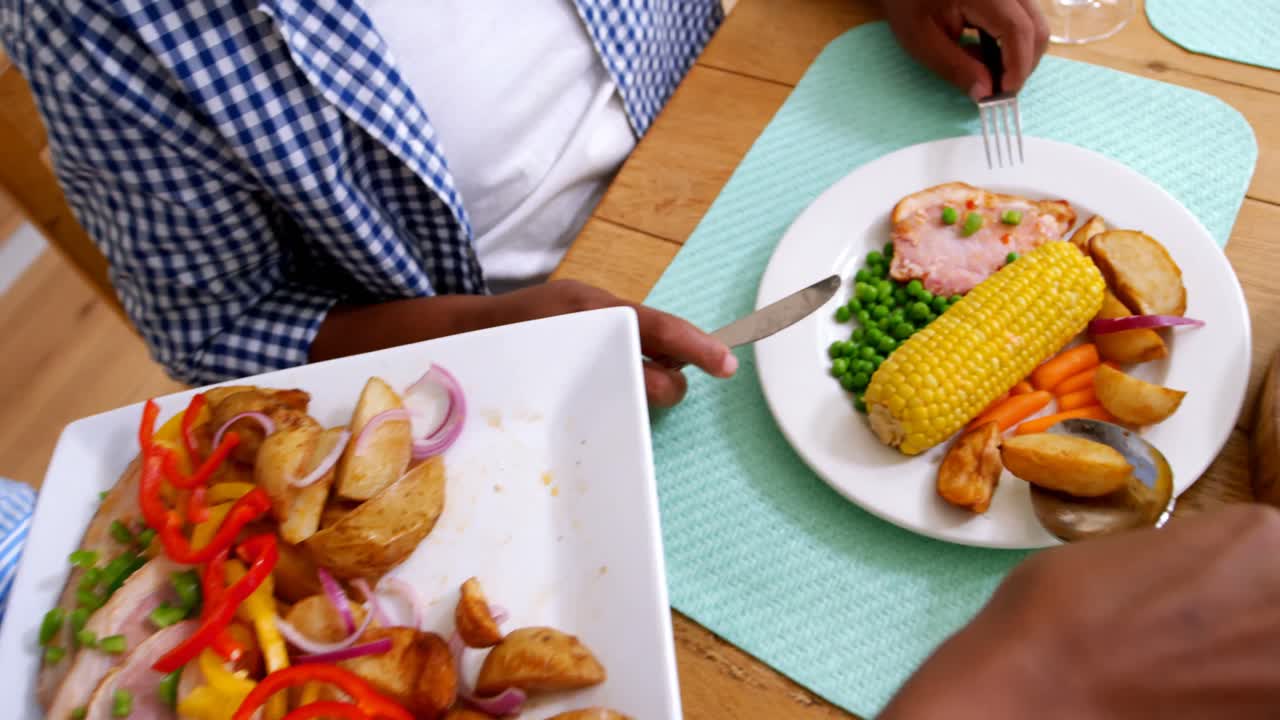 mujer sirviendo comida al hombre en la mesa de comedor