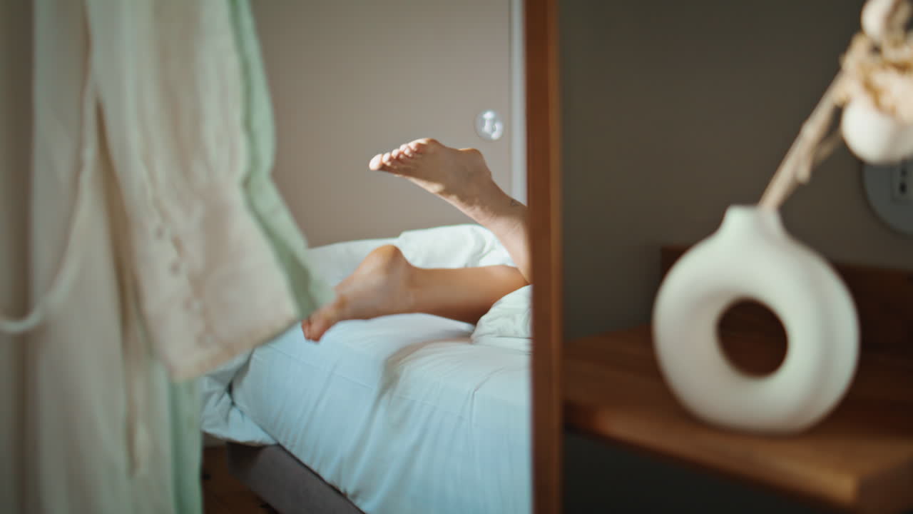 Woman feet lying bed in mirror reflection closeup. Teenager resting cozy home