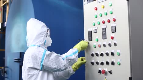 trabajador de la fábrica de energía de quema de residuos en ropa de trabajo y con máscara encendiendo el interruptor del generador del incinerador de basura