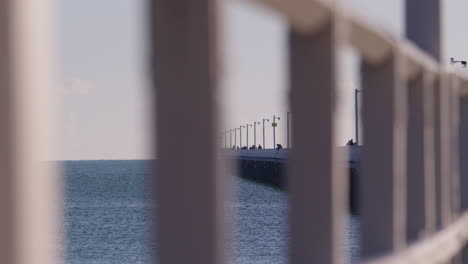 Nahaufnahme-Des-Geländers-Auf-Der-Pierpromenade-Von-Hervey-Bay-Mit-Perspektive-Auf-Den-Meereshorizont-Und-Den-Langen-Steg,-4k