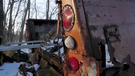 la parte trasera retro rompe las luces del viejo camión oxidado que se corroe en la madera cubierta de nieve.