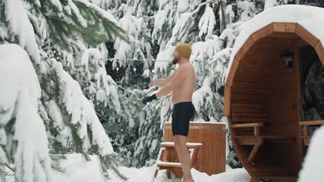 caucasian man warming up before winter swim in barrel