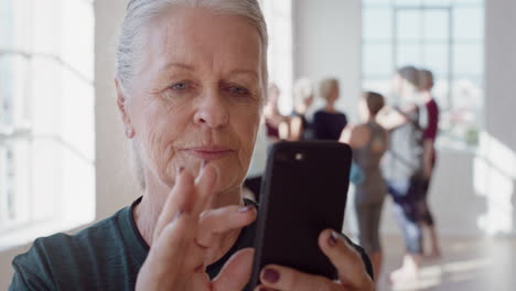 close-up-portrait-beautiful-old-woman-using-smartphone-in-yoga-class-sharing-healthy-lifestyle-on-social-media-enjoying-browsing-meditation-practices-online-in-fitness-studio
