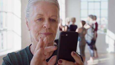 close up portrait beautiful old woman using smartphone in yoga class sharing healthy lifestyle on social media enjoying browsing meditation practices online in fitness studio