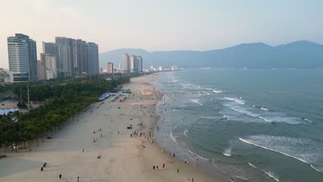 beachfront hotels and crowded people at da nang in vietnam. aerial drone shot