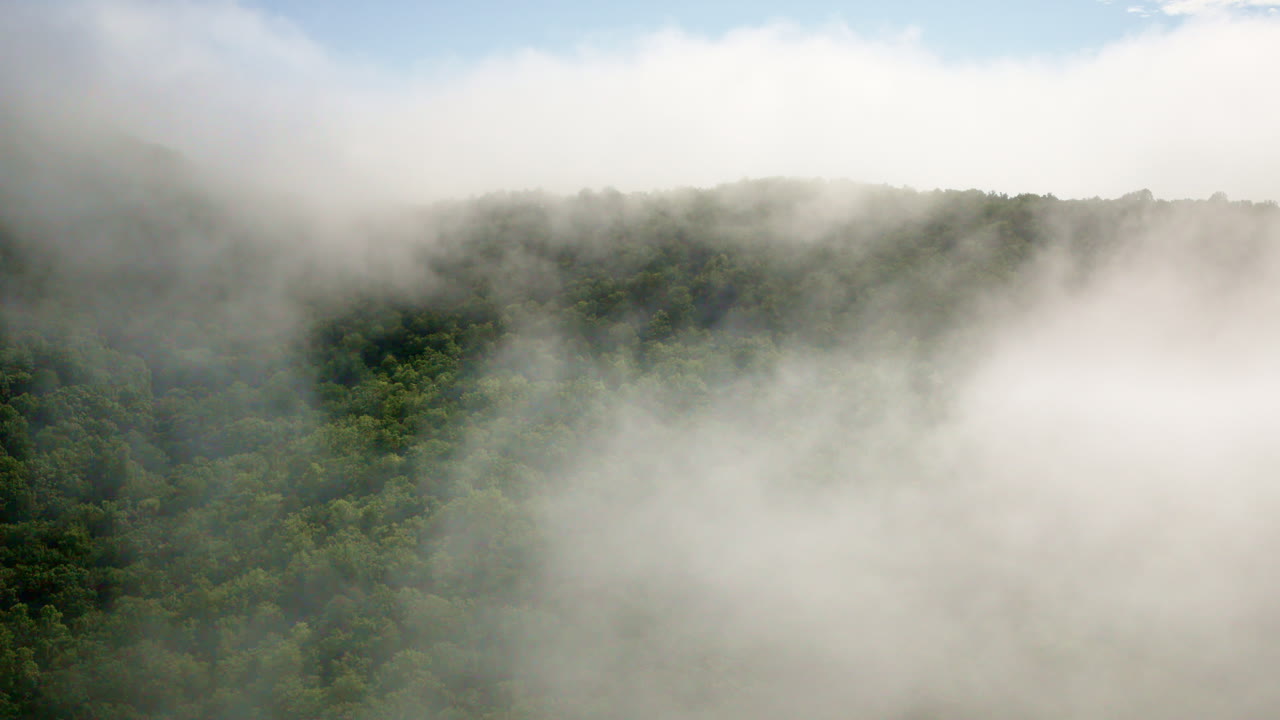 Cinematic drone shot flying slowly into fog and mist sitting on the smoky mountains