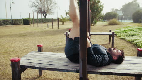 man does intense exercise using city park structures