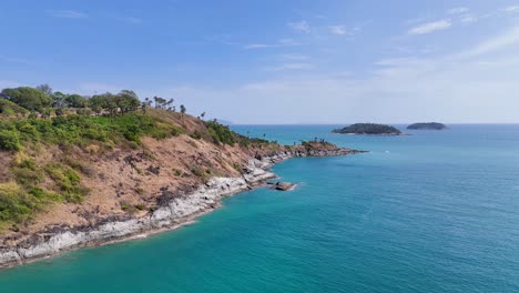 las imágenes de drones capturan la impresionante costa de promthep cape, phuket, mostrando aguas azules vibrantes y exuberante vegetación.