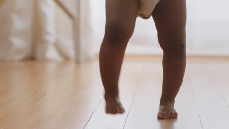 happy baby girl learning to walk toddler exploring home curious infant walking through house enjoying childhood