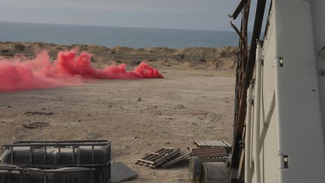 testing a red smoke bomb on the beach in the gaza strip, palestine