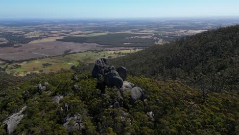 aerial orbit of boulder lookout in australian bush, farmland in background