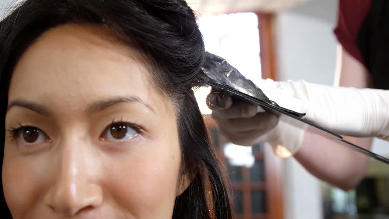 Parrucchiera che tinge i capelli della sua cliente