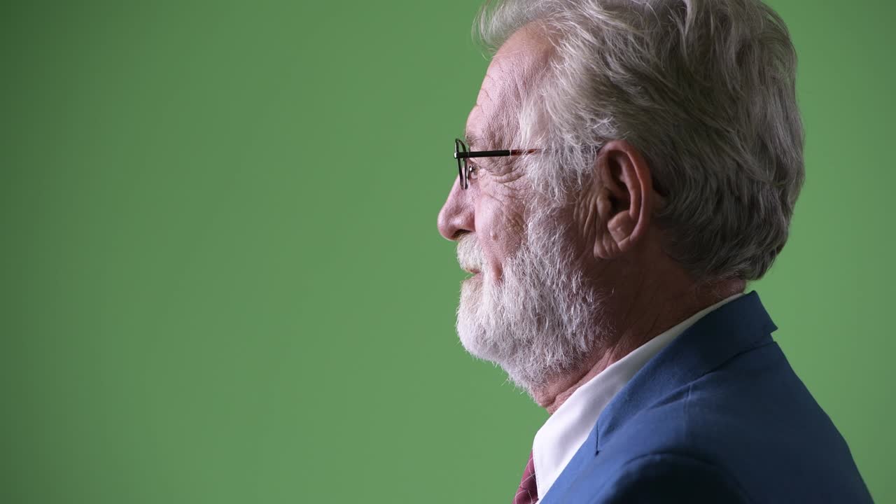 hombre de negocios barbudo y guapo contra un fondo verde.