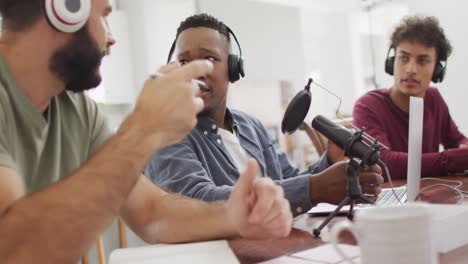 happy diverse male friends talking and recording in living room