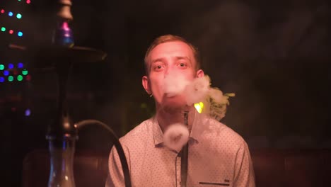 man smoking hookah at night