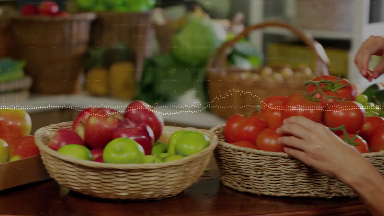 Hands entering frame, woman selecting vine tomatoes on market stall, inspecting and presenting