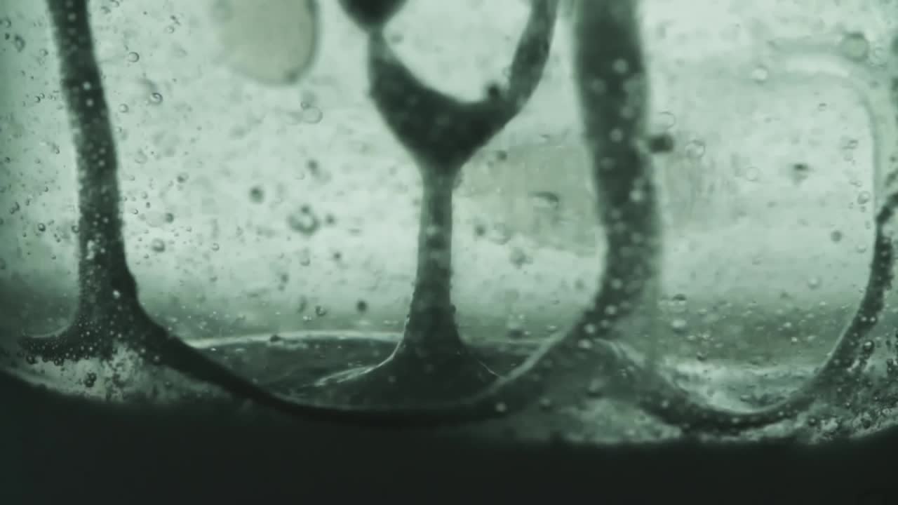 물 거품으로 흐르는 기름의 고속 느린 움직임은 천천히 위로 올라갑니다.