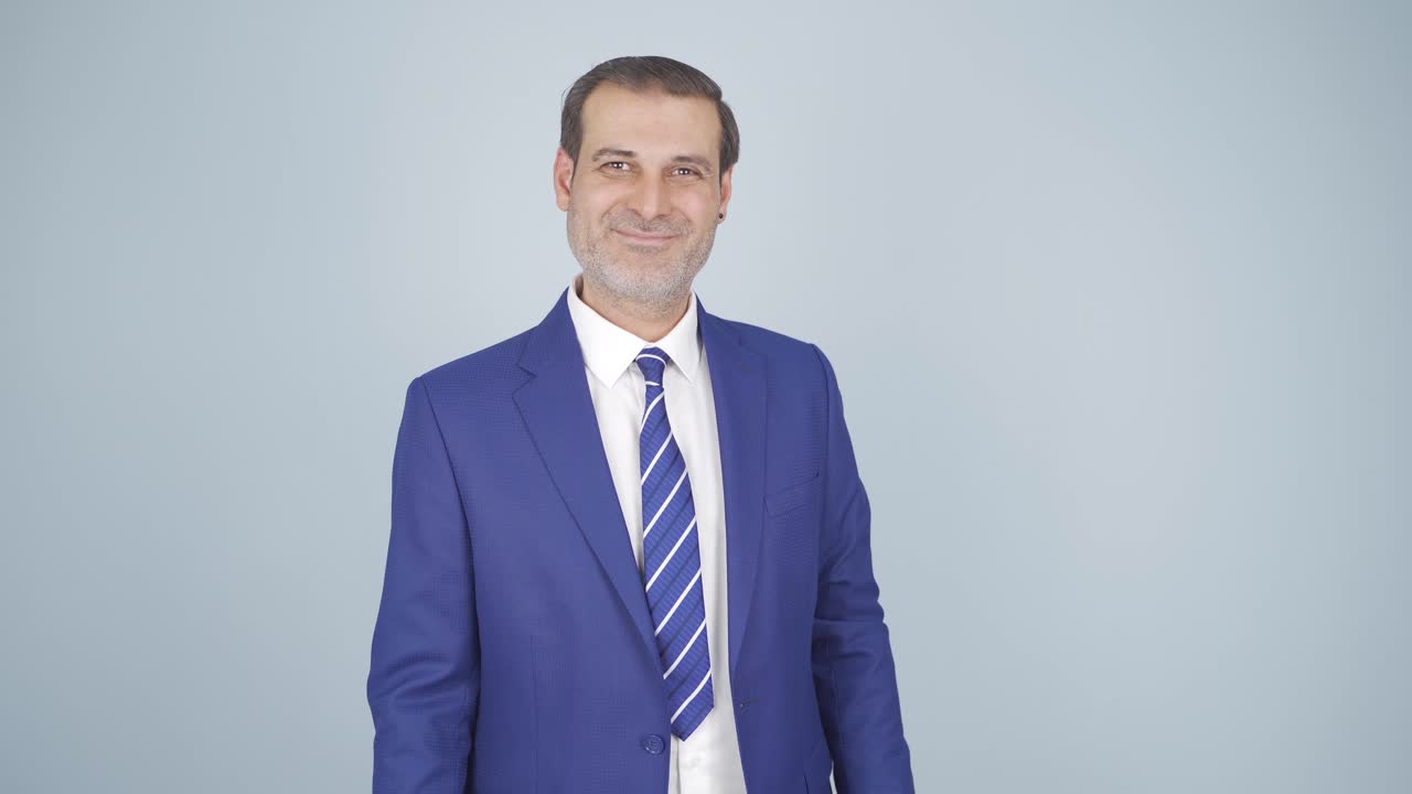 Empresário acenando com a cabeça para a câmera. Aprovação