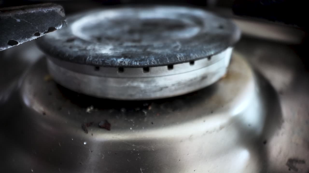 Gas stove with dirty burner and food residues after cooking, representing unhealthy lifestyle and lack of cleaning