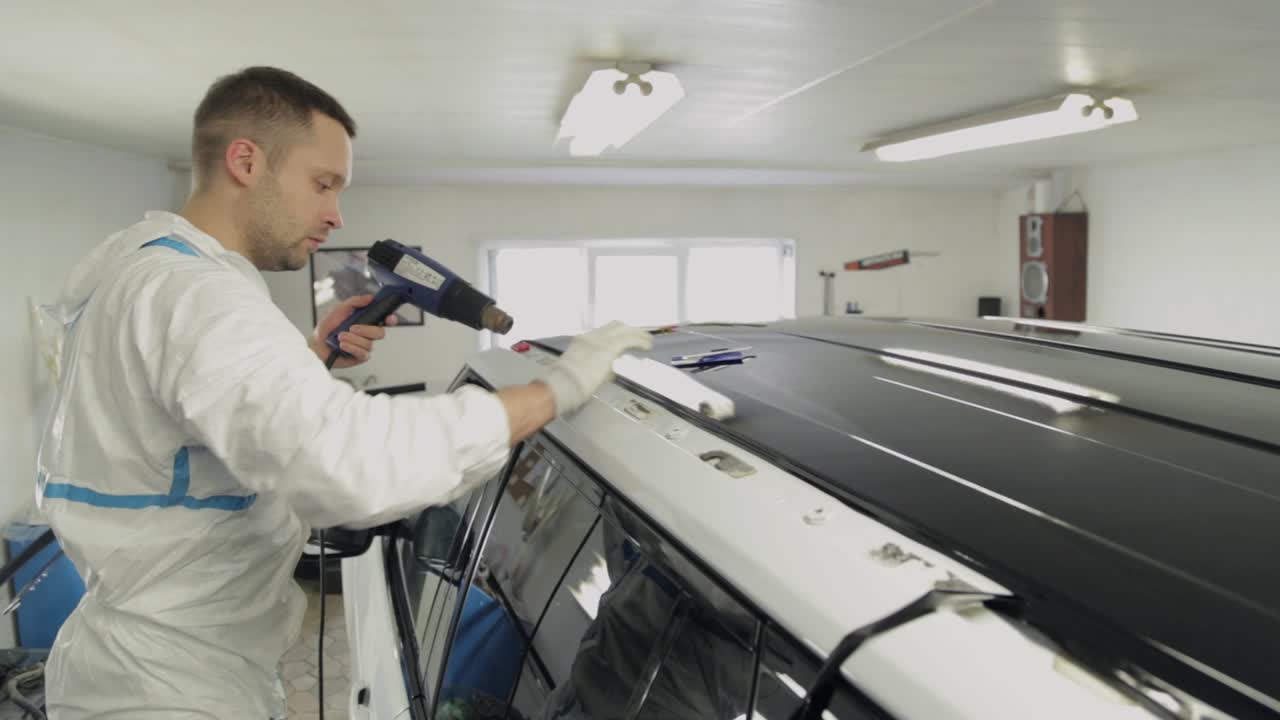 Applying Vinyl Wrap to Car Roof with Heat Gun
