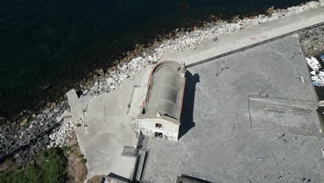 aerial drone top down shot over an old church alongside lake tekapo, pozzuoli, italy on a sunny day