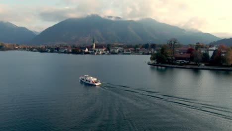 aerial landscape view of lake with a ferry and a lake side city in germany during sunset