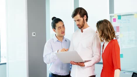 Business-colleagues-discussing-over-laptop