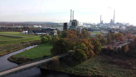 Ascending-aerial-showing-chemical-plant-factory-next-to-river,germany