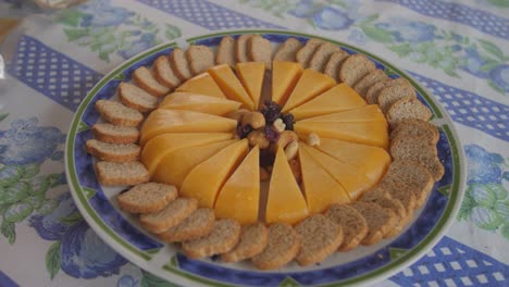 pieces of cheese, nuts and raisins with pieces of baguette bread on a plate