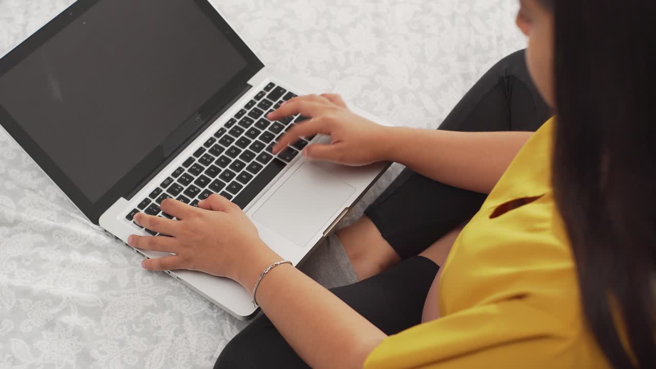 一位年輕的拉丁裔女性在筆記型電腦上工作