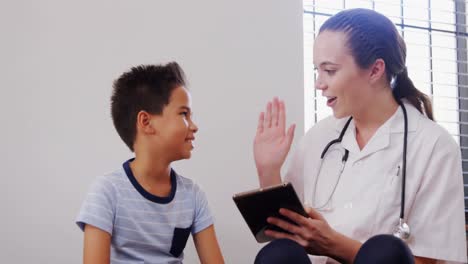 Female-physiotherapist-giving-high-five-to-boy-patient-4k