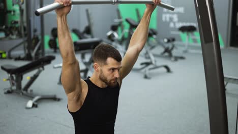 Male-training-back-and-hands-muscles-doing-pulls-weight-exercise-in-a-gym