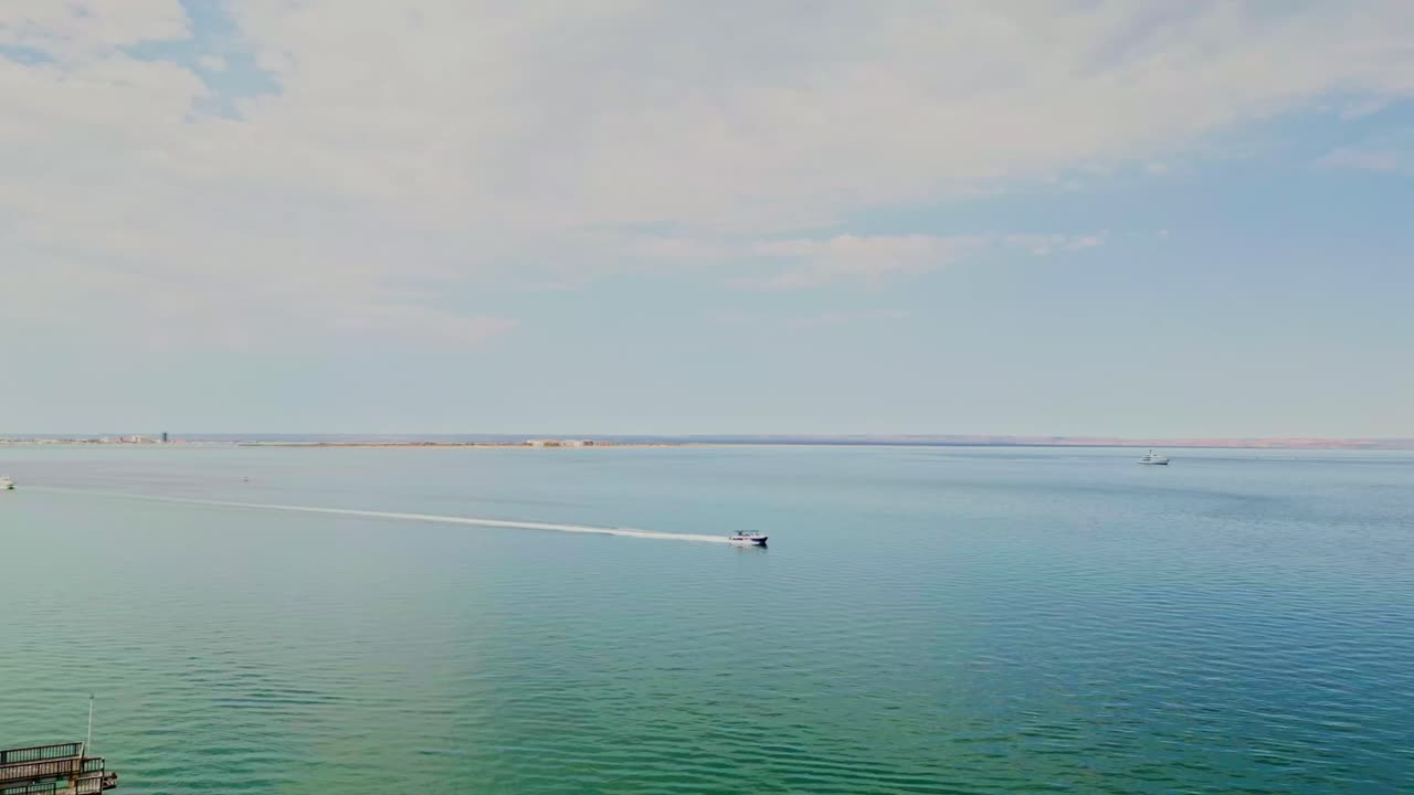 Sunny view of Playa Coromuel in La Paz, shot from a drone over the water