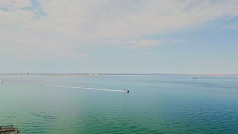 sunny view of playa coromuel in la paz, shot from a drone over the water